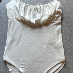 white ruched body suit with button closure.